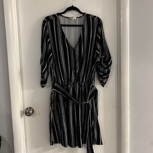 Black and white striped dress with circle tie belt and button up sleeves.